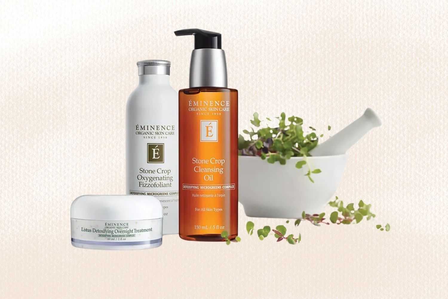 Éminence skin care products displayed with a mortar and pestle filled with fresh green herbs.