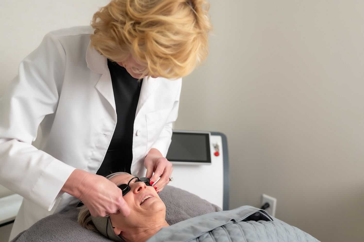 Sheri Ikerd of Collective Beauty Salon and Med Spa helping a patient before a laser procedure.